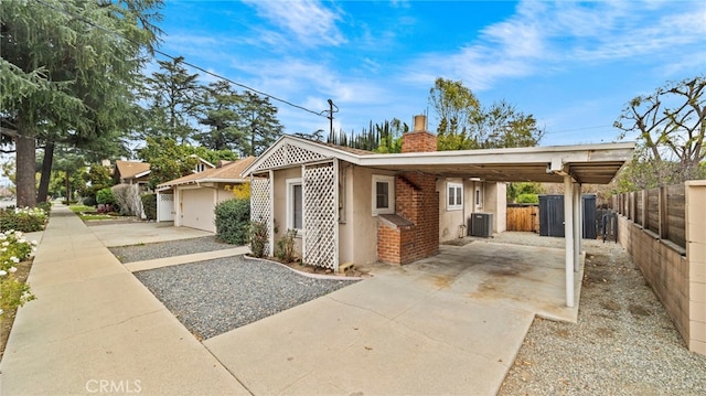 view of property exterior featuring central AC, a carport, and a garage