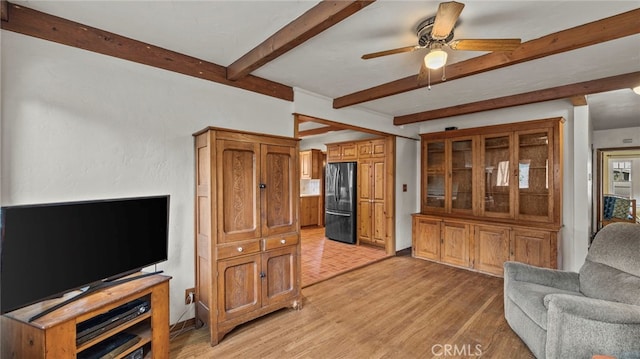 living room featuring ceiling fan, beam ceiling, and light wood-type flooring