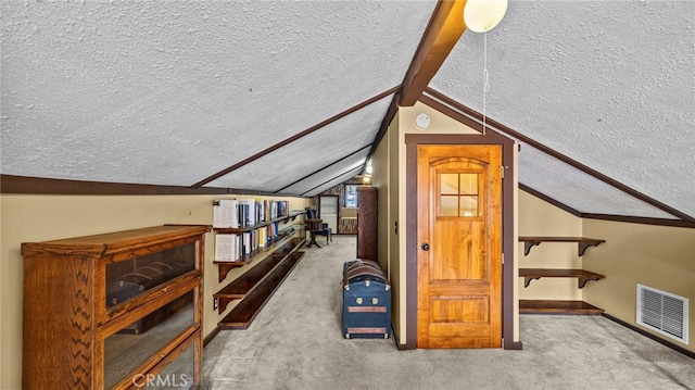 additional living space featuring carpet floors, lofted ceiling with beams, and a textured ceiling