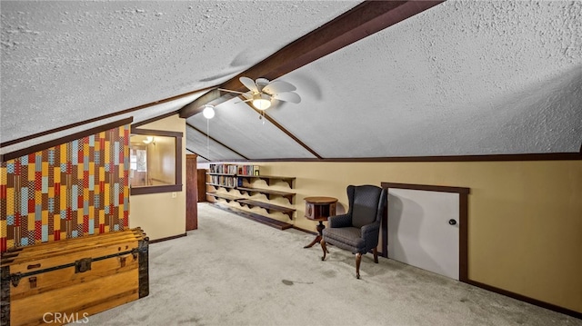 living area with ceiling fan, carpet, a textured ceiling, and vaulted ceiling with beams