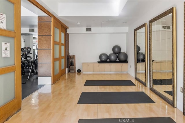 workout area featuring french doors and light hardwood / wood-style floors