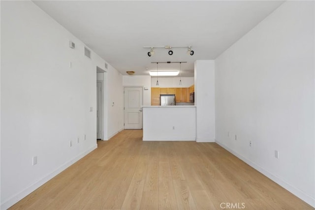 unfurnished living room featuring light hardwood / wood-style flooring and track lighting