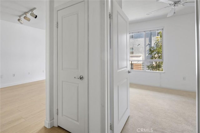 hallway with track lighting and light hardwood / wood-style floors