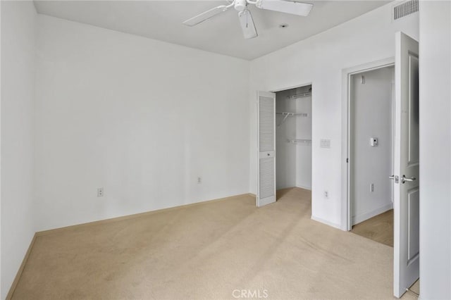 unfurnished bedroom with light carpet, a closet, and ceiling fan