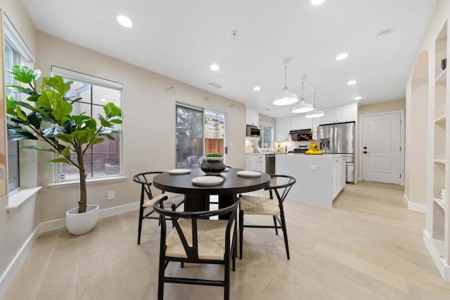 dining area with plenty of natural light and light hardwood / wood-style floors