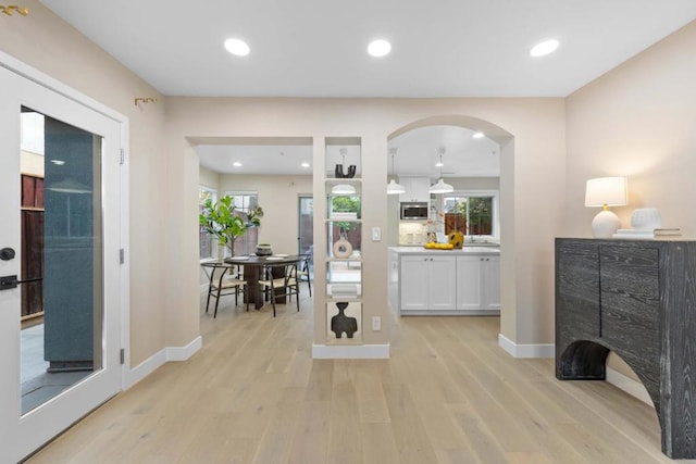 interior space with white cabinetry, a healthy amount of sunlight, and light wood-type flooring