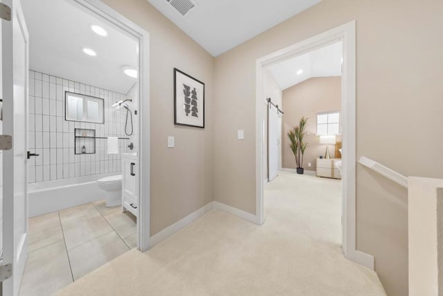 bathroom featuring tiled shower / bath combo, lofted ceiling, tile patterned floors, and toilet