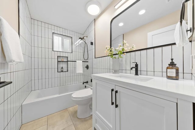 full bathroom with toilet, tiled shower / bath, tile walls, vanity, and tile patterned flooring