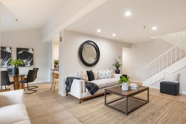 living room with vaulted ceiling and light wood-type flooring