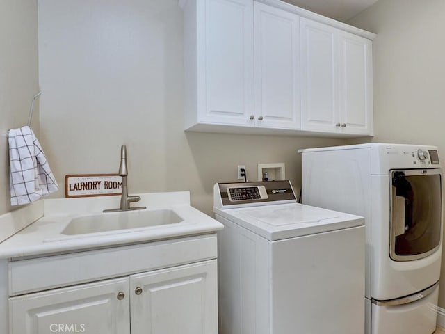 washroom with cabinets, sink, and independent washer and dryer