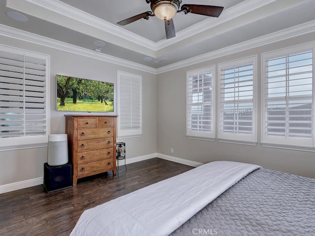 bedroom featuring a raised ceiling, crown molding, dark hardwood / wood-style floors, and ceiling fan