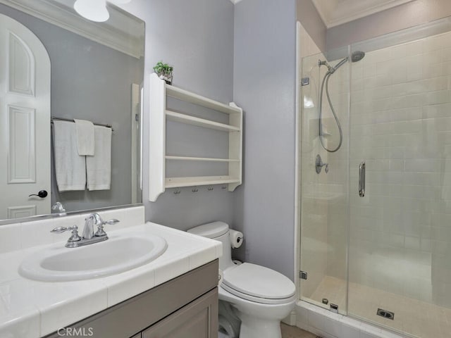 bathroom with vanity, crown molding, a shower with door, and toilet