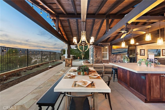 patio terrace at dusk with an outdoor bar and ceiling fan