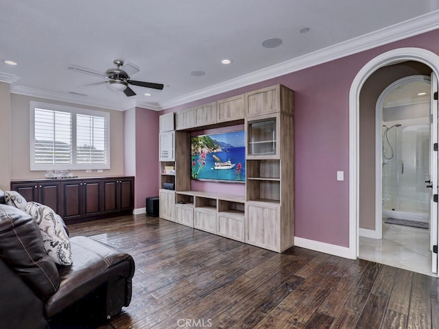 living room with dark wood-type flooring, ornamental molding, and ceiling fan