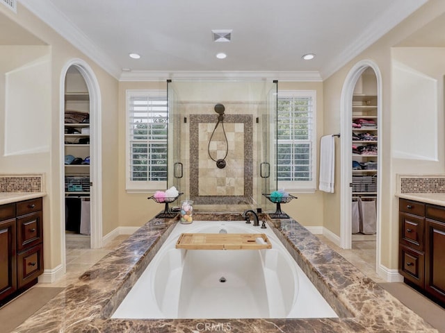 bathroom with a healthy amount of sunlight, vanity, plus walk in shower, and ornamental molding