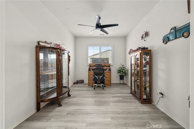 office space featuring a ceiling fan, light wood-style floors, and baseboards