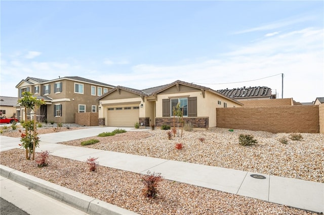 view of front of home featuring fence, stucco siding, a garage, stone siding, and driveway