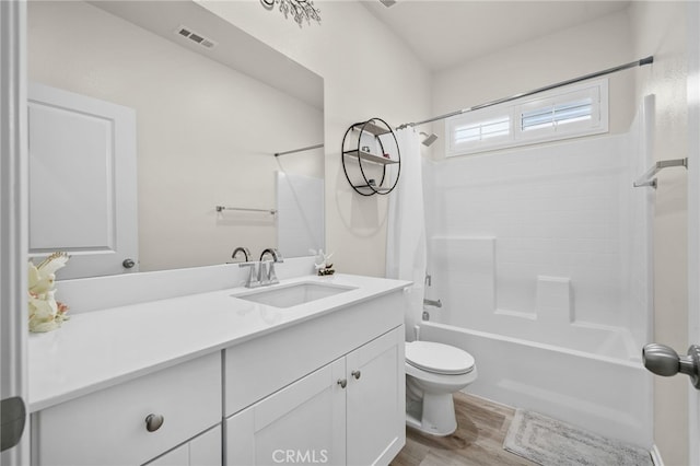 full bath with vanity, wood finished floors, visible vents, shower / tub combo, and toilet