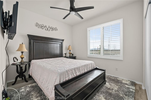 bedroom with ceiling fan, baseboards, and wood finished floors