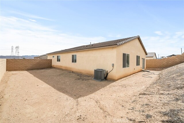 view of property exterior with central AC unit, a fenced backyard, and stucco siding