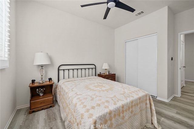 bedroom featuring visible vents, baseboards, a closet, and wood finished floors