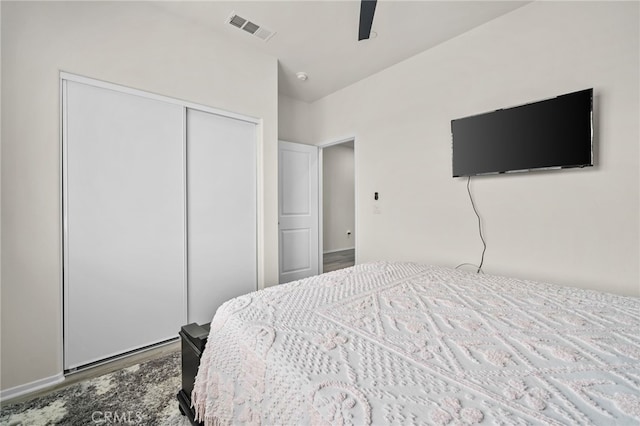 bedroom with ceiling fan, visible vents, a closet, and wood finished floors