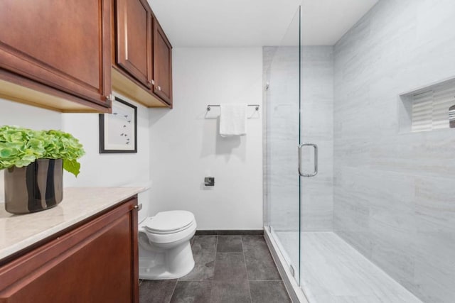 bathroom with vanity, a shower with shower door, and toilet