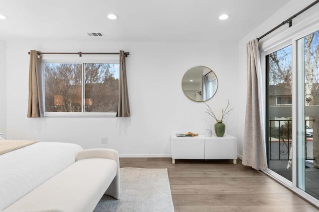 bedroom featuring hardwood / wood-style flooring, multiple windows, and access to outside