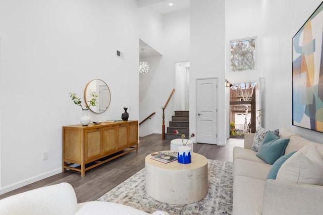 living room featuring a high ceiling, a chandelier, and dark hardwood / wood-style flooring