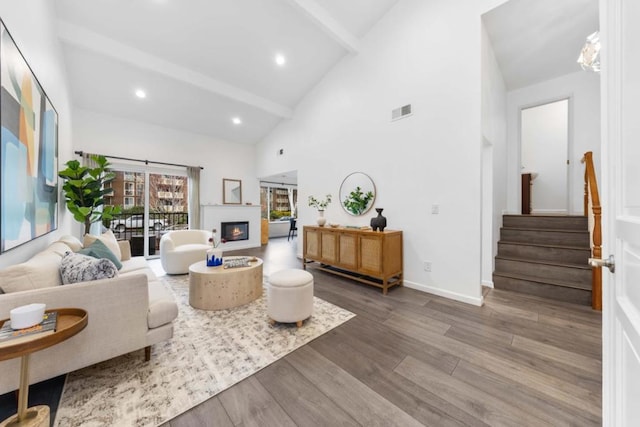 living room with wood-type flooring, high vaulted ceiling, and beamed ceiling