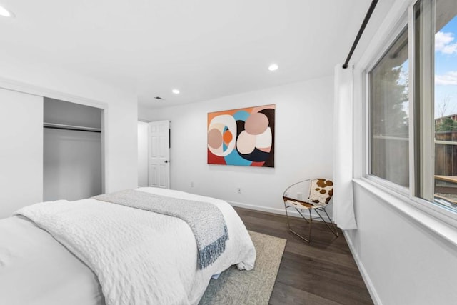 bedroom with dark wood-type flooring and a closet