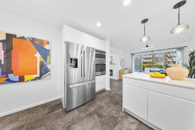 kitchen featuring pendant lighting, appliances with stainless steel finishes, and white cabinets