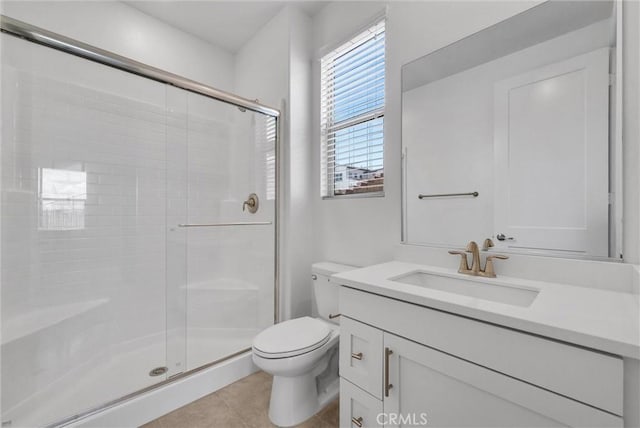 bathroom featuring vanity, tile patterned flooring, a shower with shower door, and toilet