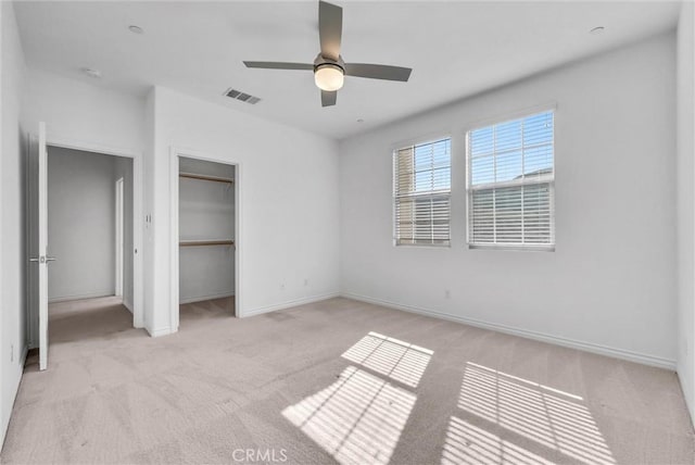 unfurnished bedroom with ceiling fan, light colored carpet, and a closet