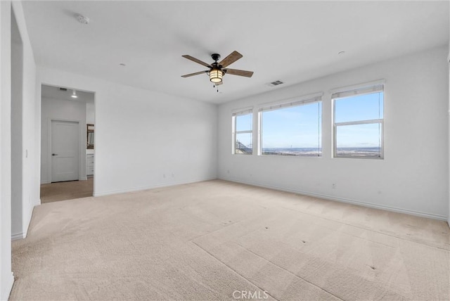 empty room with ceiling fan and light colored carpet