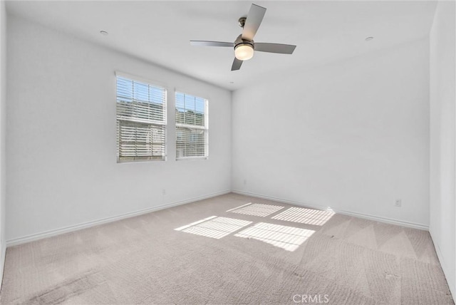 spare room with light colored carpet and ceiling fan