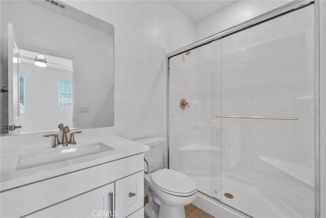 bathroom featuring vanity, a shower with door, and toilet