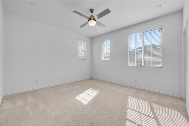 carpeted spare room featuring ceiling fan