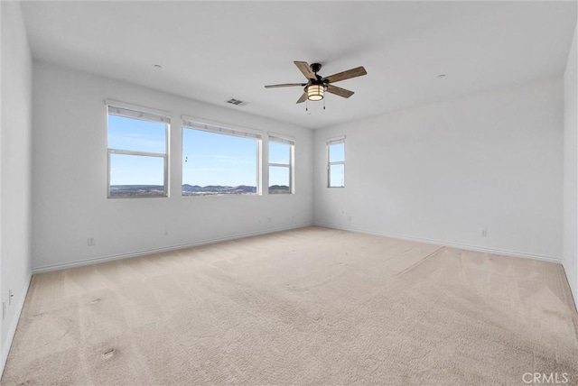 empty room featuring light colored carpet and ceiling fan