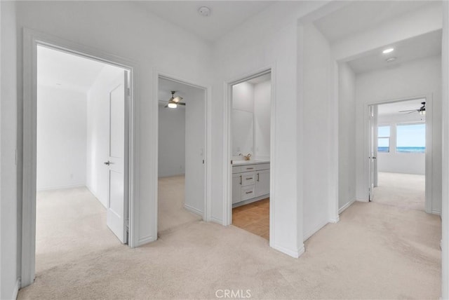 hallway featuring light colored carpet