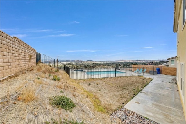 view of pool with a patio and a mountain view