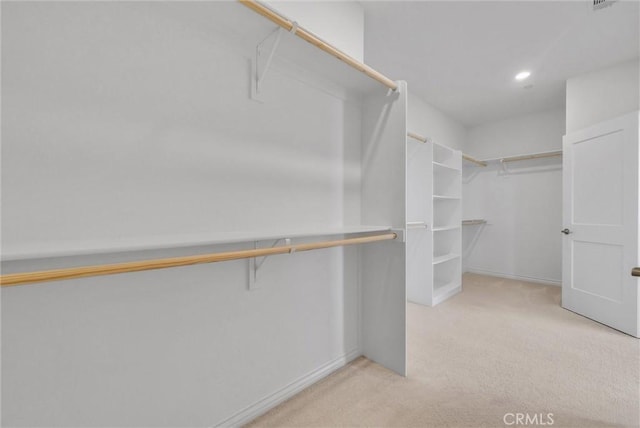 walk in closet featuring light carpet