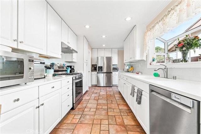 kitchen with decorative backsplash, white cabinetry, stainless steel appliances, and sink