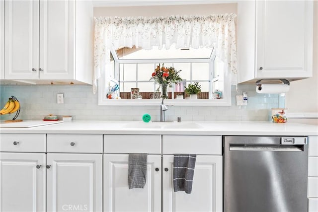 kitchen with white cabinets, sink, backsplash, and stainless steel dishwasher