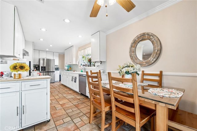 kitchen featuring appliances with stainless steel finishes, white cabinets, crown molding, and ceiling fan