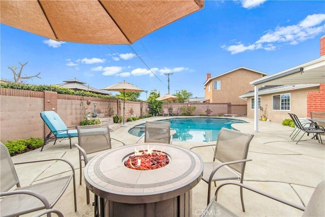 view of pool with an outdoor fire pit and a patio