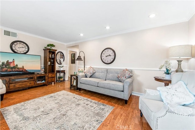 living room with light hardwood / wood-style flooring and crown molding