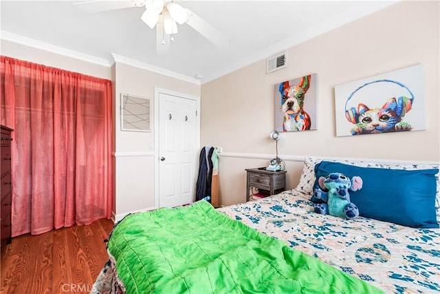 bedroom featuring dark hardwood / wood-style flooring, ornamental molding, and ceiling fan