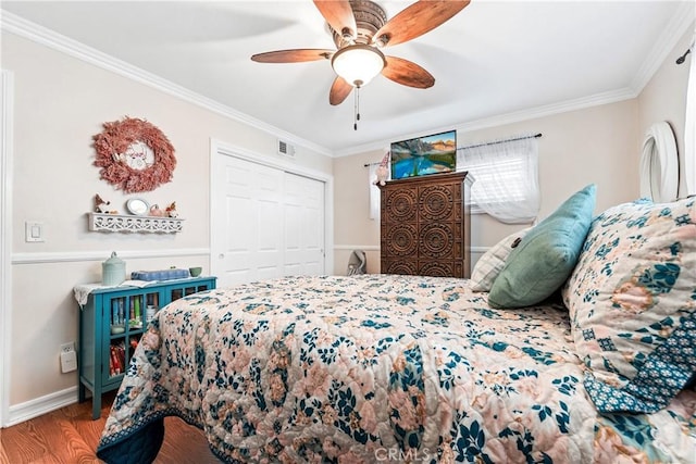 bedroom featuring ceiling fan, hardwood / wood-style flooring, crown molding, and a closet