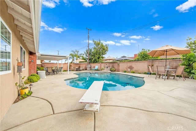 view of pool featuring a patio and a diving board